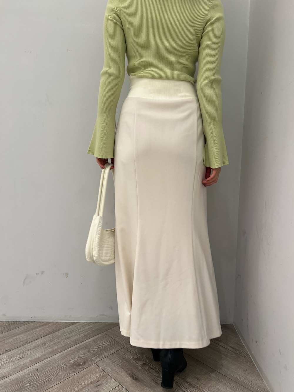 グリーン系のニット/セーター、ホワイト系のスカートを着用したレディースの冬コーディネートの10枚目の写真