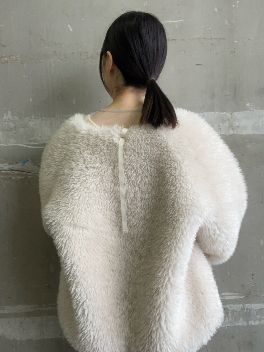 ホワイト系のブルゾン、ホワイト系のワンピース、ブラック系のブーツを着用したレディースの冬コーディネートの3枚目の写真