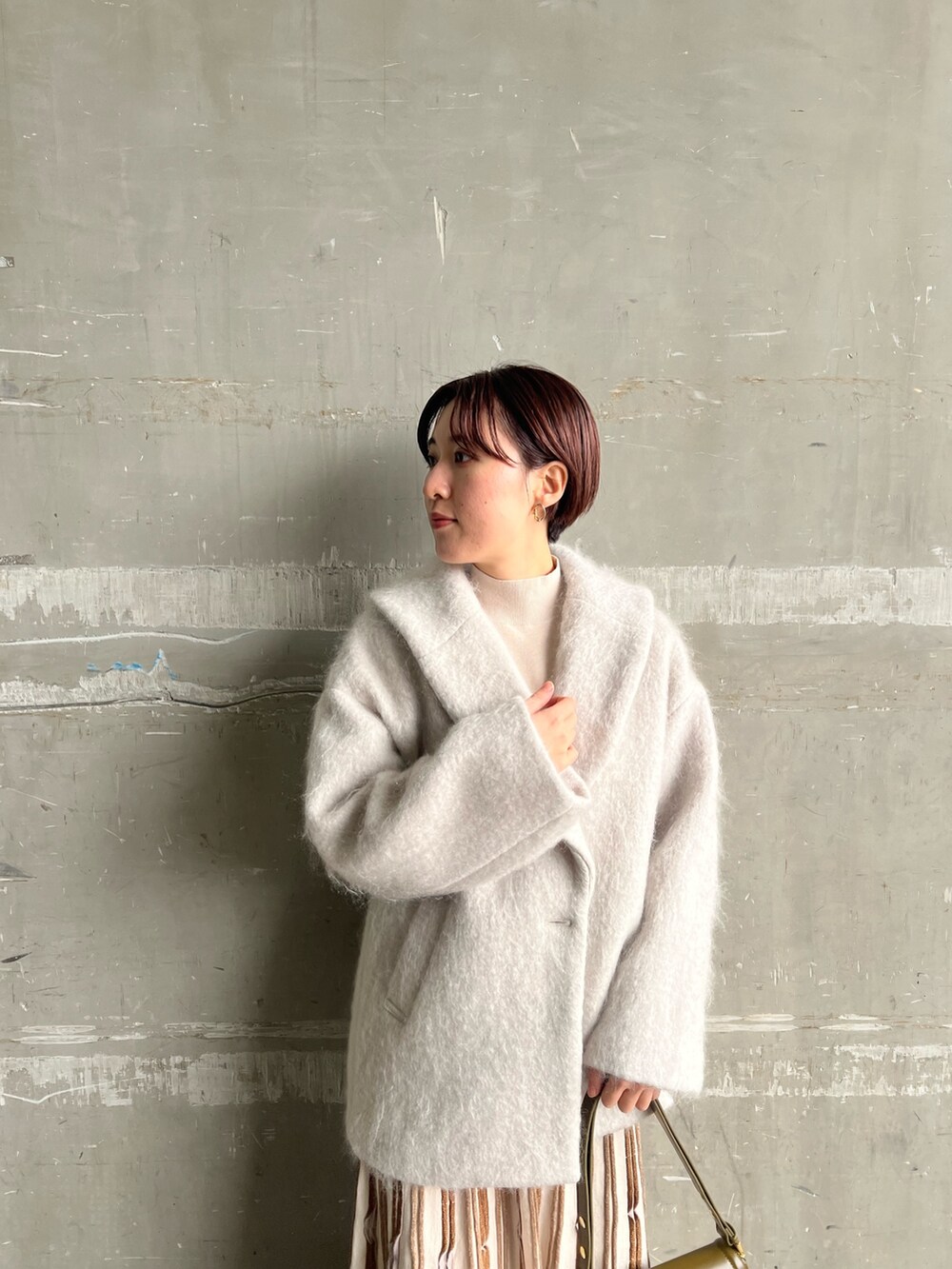 ブラウン系のショルダーバッグ、ベージュ系のブーツ、グレー系のその他アウターを着用したレディースの冬コーディネートの4枚目の写真