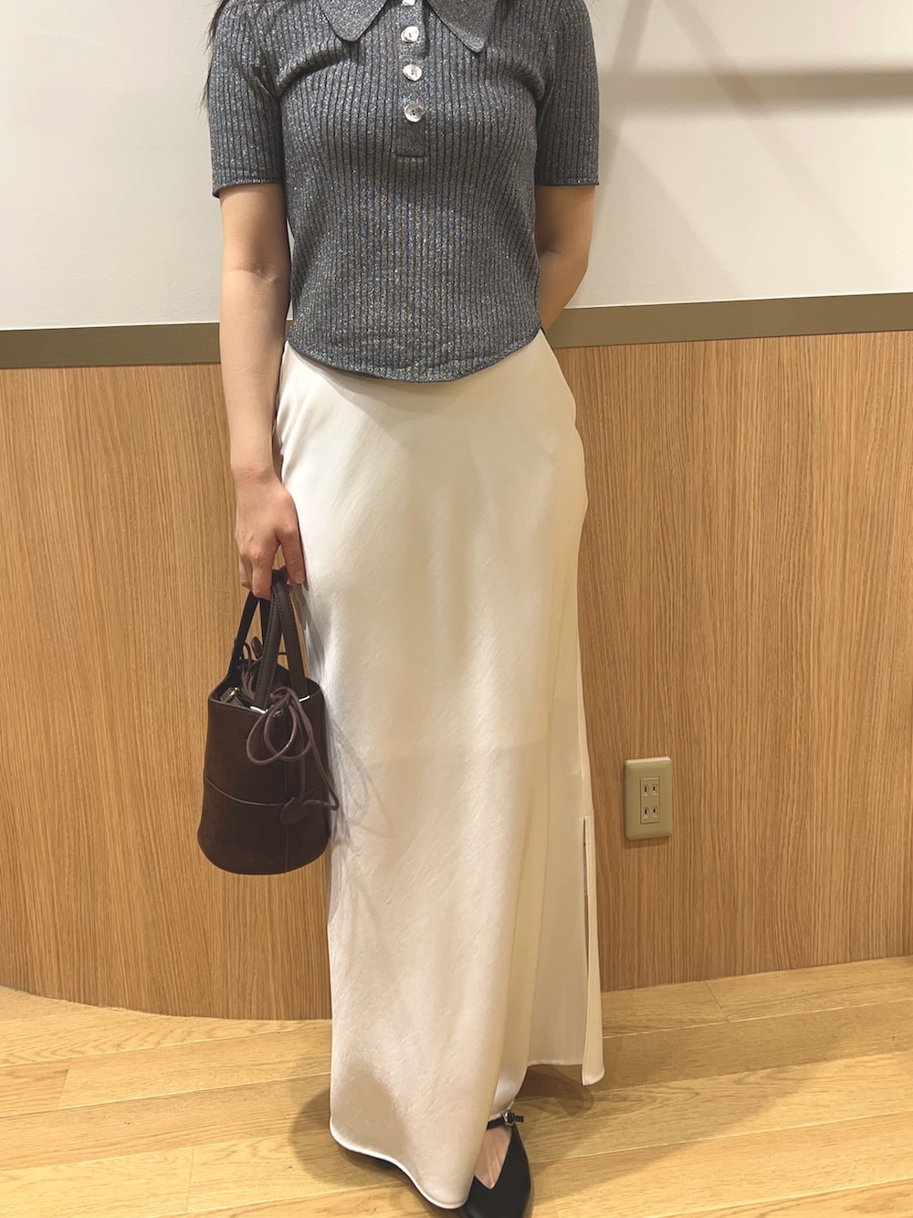 グレー系のニット/セーター、ブラック系のパンプス、ブラウン系のハンドバッグを着用したレディースの春コーディネートの6枚目の写真