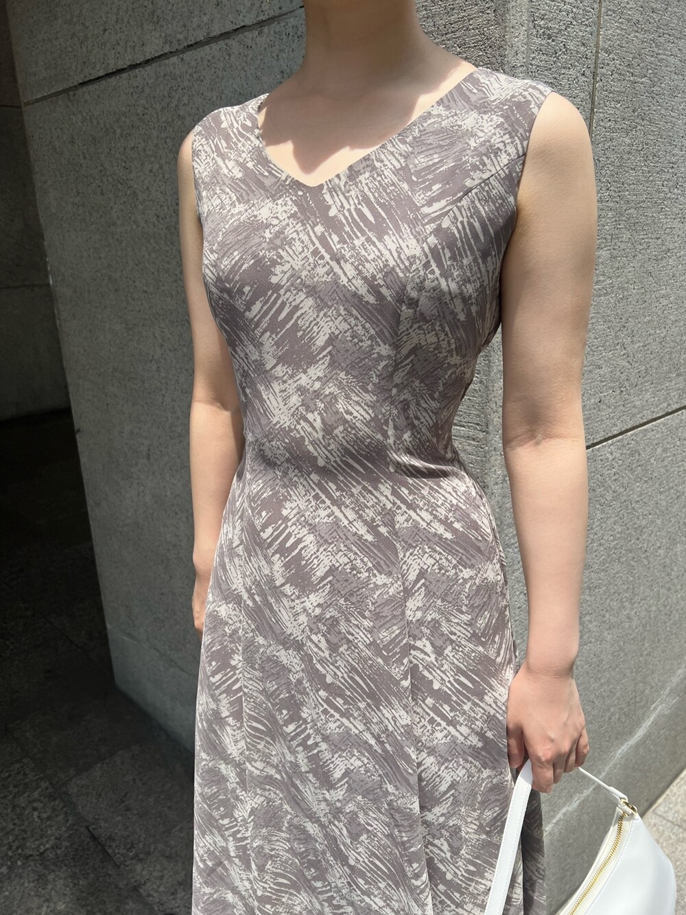 ホワイト系のハンドバッグ、ベージュ系のサンダル、グレー系のワンピースを着用したレディースの夏コーディネートの9枚目の写真