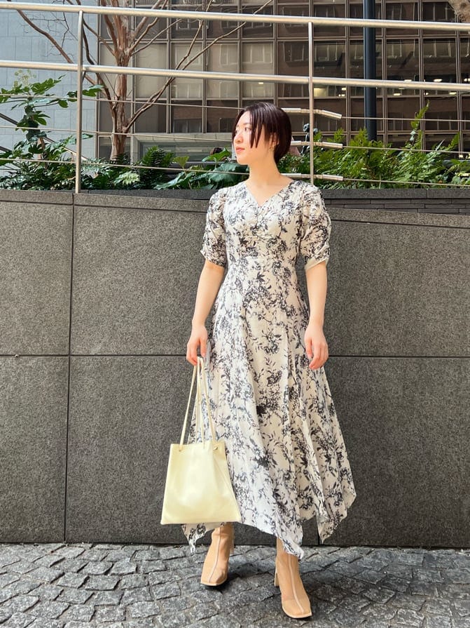 ベージュ系のブーツ、ホワイト系のハンドバッグ、イエロー系のカーディガン/ボレロを着用したレディースの春コーディネートの4枚目の写真