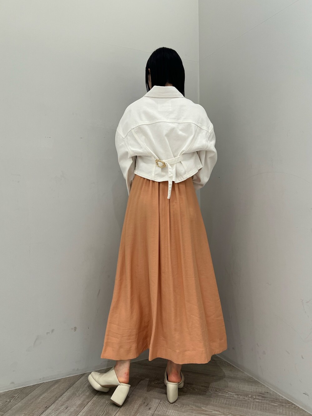 ホワイト系のサンダル、オレンジ系のワンピース、ホワイト系のデニムジャケットを着用したレディースの春コーディネートの2枚目の写真