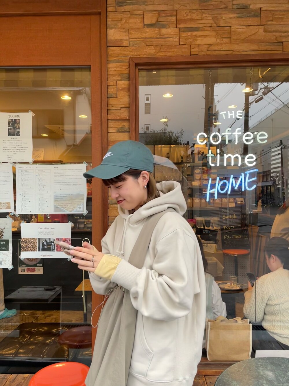 ホワイト系のパーカー、ホワイト系のスニーカー、グレー系のショルダーバッグを着用したレディースの春コーディネートの4枚目の写真