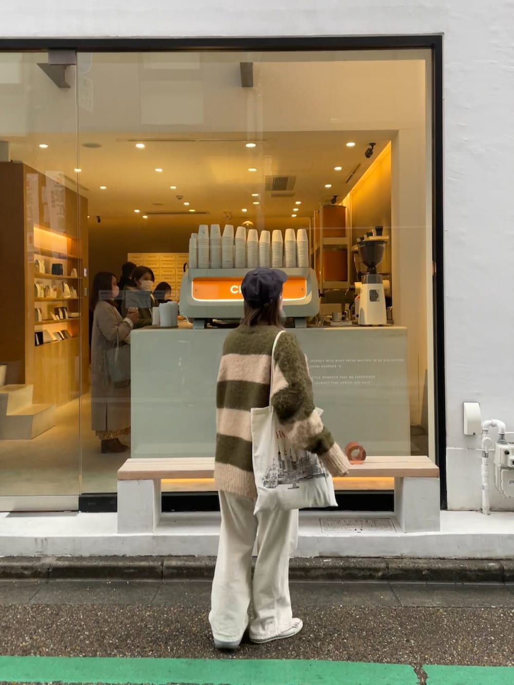 ホワイト系のデニムパンツ、ホワイト系のトートバッグ、ホワイト系のスニーカーを着用したレディースの春コーディネートの2枚目の写真