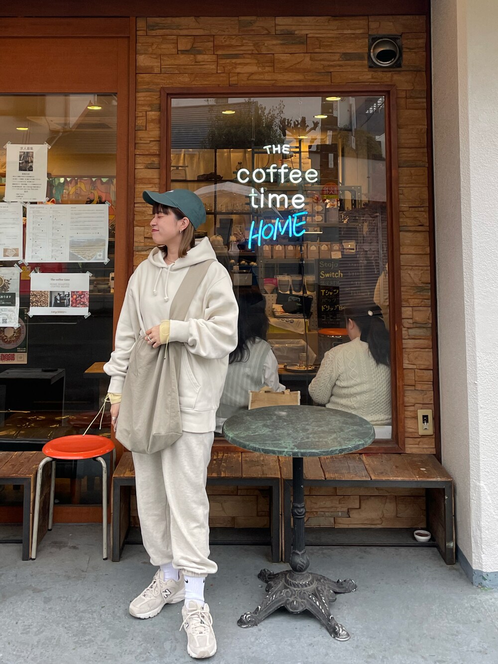 ホワイト系のパーカー、ホワイト系のスニーカー、グレー系のショルダーバッグを着用したレディースの春コーディネートの2枚目の写真