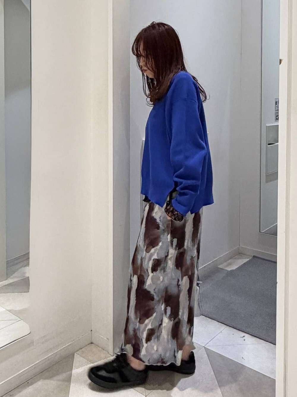 ブラック系のスニーカー、ブラック系のTシャツ/カットソー、ブルー系のニット/セーターを着用したレディースの冬コーディネートの4枚目の写真