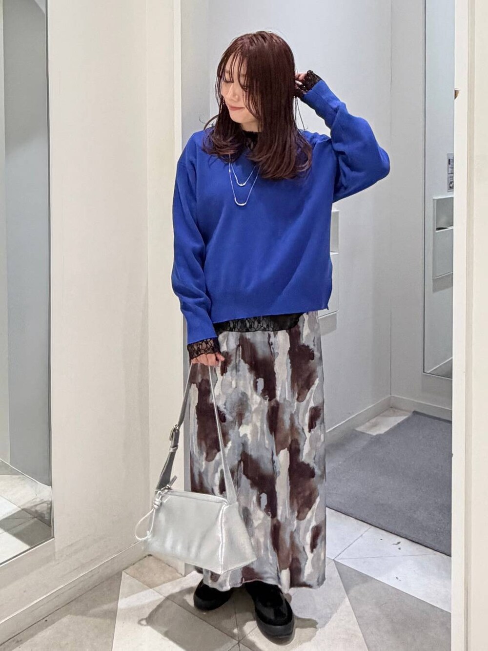 ブラック系のスニーカー、ブラック系のTシャツ/カットソー、ブルー系のニット/セーターを着用したレディースの冬コーディネートの6枚目の写真
