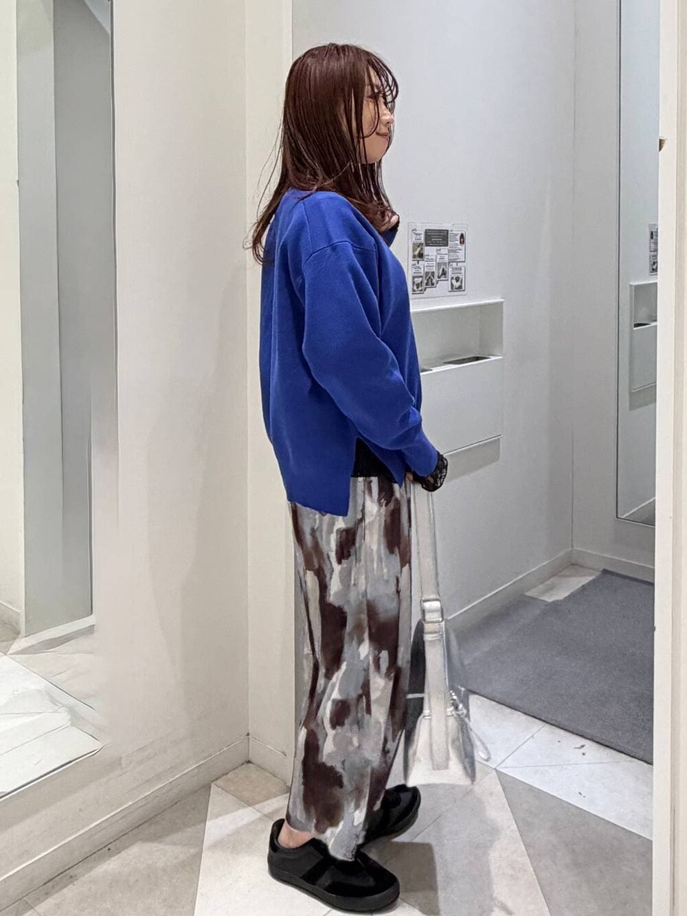 ブラック系のスニーカー、ブラック系のTシャツ/カットソー、ブルー系のニット/セーターを着用したレディースの冬コーディネートの2枚目の写真