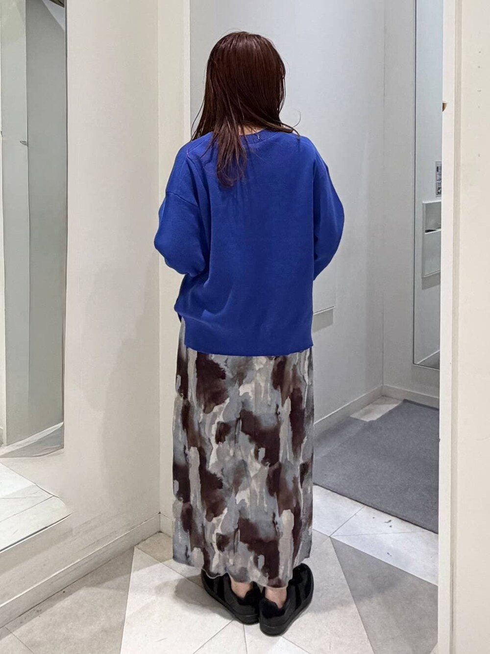 ブラック系のスニーカー、ブラック系のTシャツ/カットソー、ブルー系のニット/セーターを着用したレディースの冬コーディネートの3枚目の写真