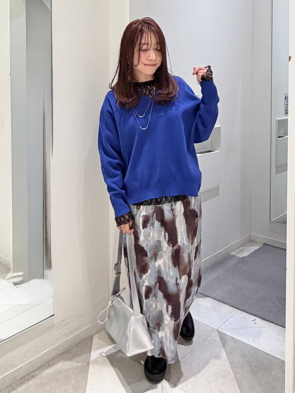 ブラック系のスニーカー、ブラック系のTシャツ/カットソー、ブルー系のニット/セーターを着用したレディースの冬コーディネートの5枚目の写真
