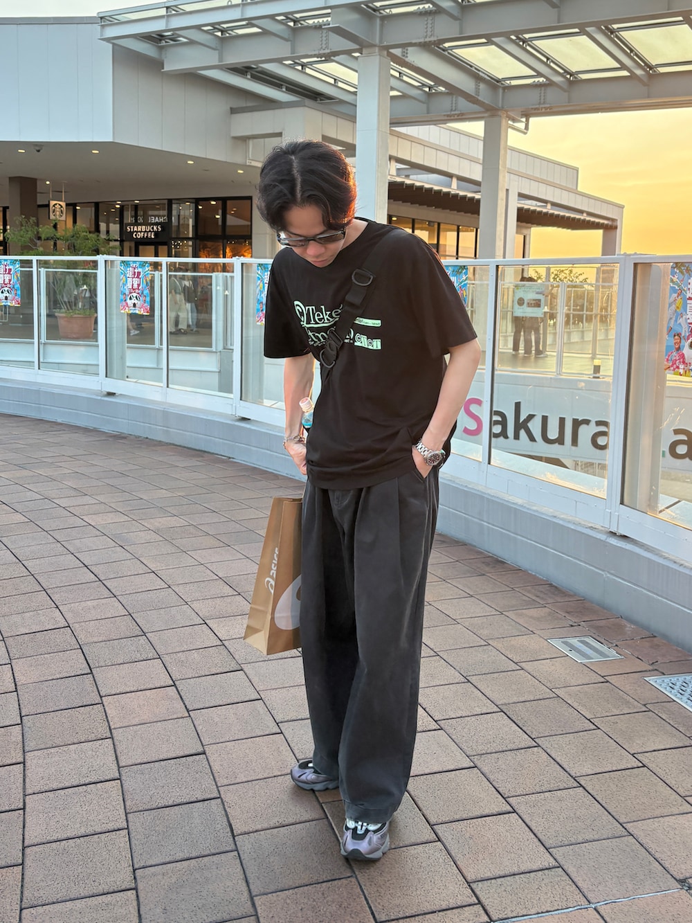 ブラック系のスラックス、パープル系のスニーカー、ブラック系のTシャツ/カットソーを着用したメンズの夏コーディネートの2枚目の写真