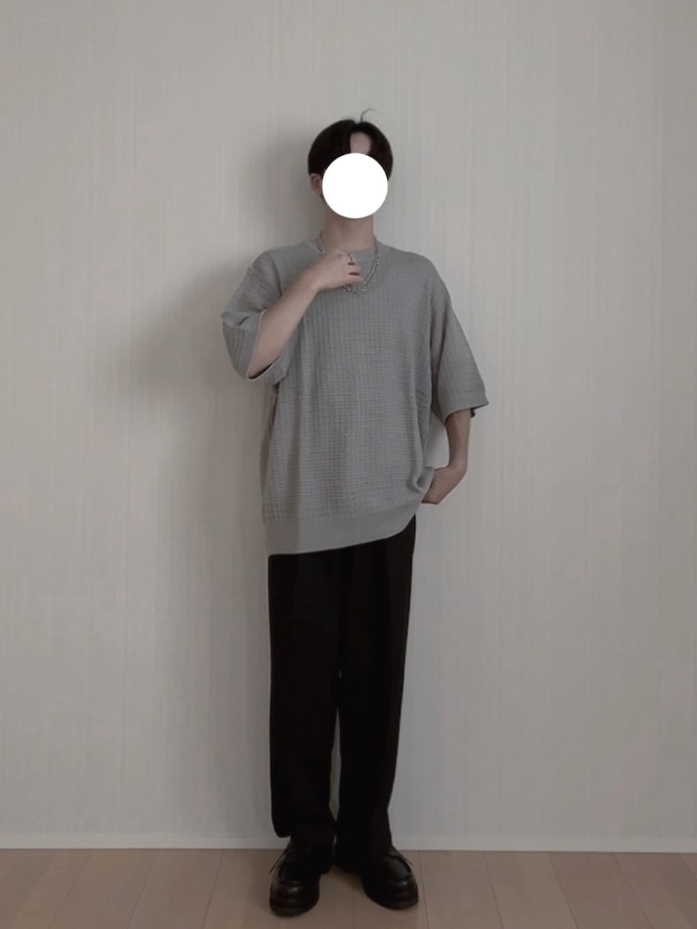 グレー系のニット/セーター、ブラック系のスラックス、ブラック系のモカシン/デッキシューズを着用したメンズの夏コーディネートの2枚目の写真