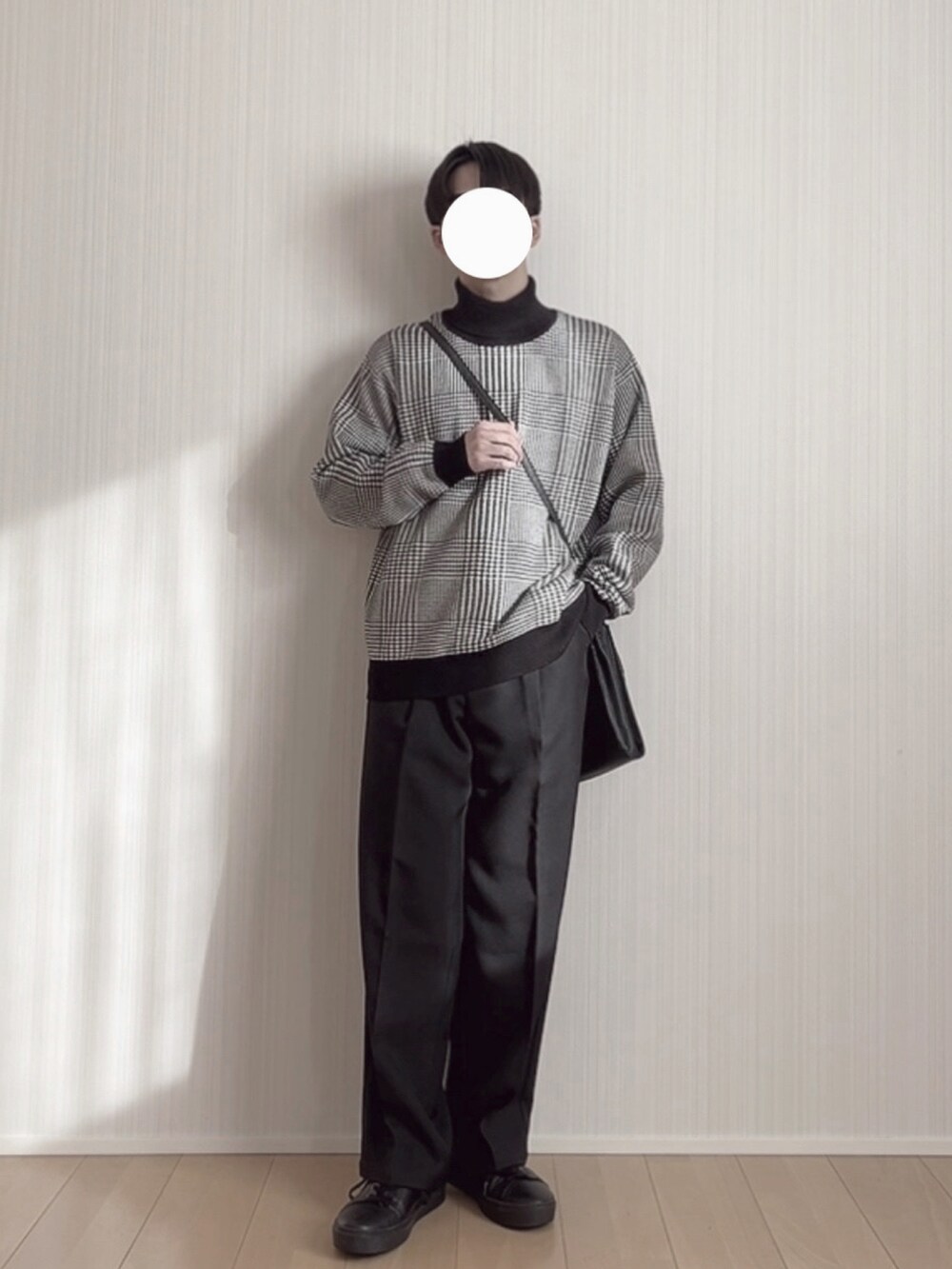 ブラック系のスラックス、ブラック系のスニーカー、ブラック系のニット/セーターを着用したメンズの冬コーディネートの2枚目の写真