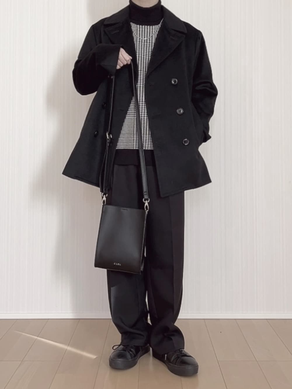 ブラック系のスニーカー、ブラック系のスラックス、ブラック系のショルダーバッグを着用したメンズの冬コーディネートの5枚目の写真