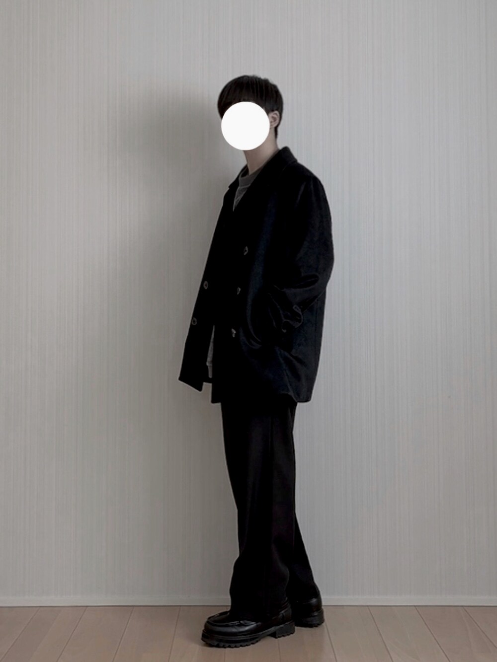 ブラック系のピーコート、ブラック系のスラックス、ブラック系のモカシン/デッキシューズを着用したメンズの冬コーディネートの3枚目の写真