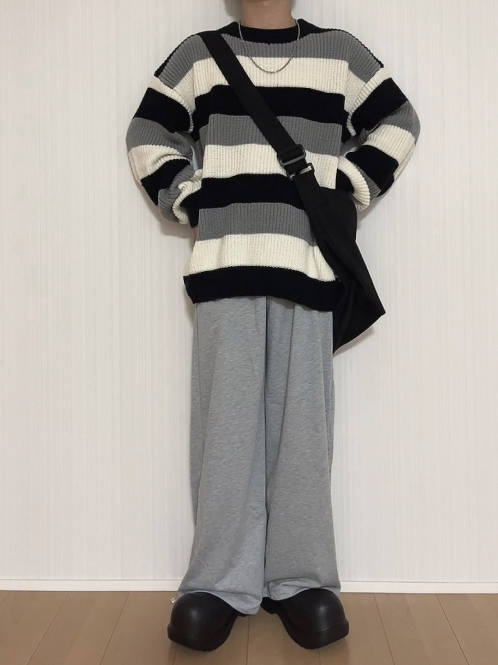 グレー系のスウェットパンツ、ブラック系のスリッポン、ブラック系のニット/セーターを着用したメンズの秋コーディネートの3枚目の写真