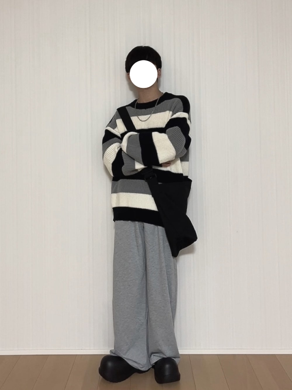 グレー系のスウェットパンツ、ブラック系のスリッポン、ブラック系のニット/セーターを着用したメンズの秋コーディネートの2枚目の写真