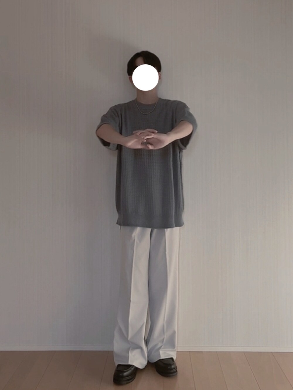 ブルー系のニット/セーター、グレー系のスラックス、ブラック系のモカシン/デッキシューズを着用したメンズの夏コーディネートの2枚目の写真