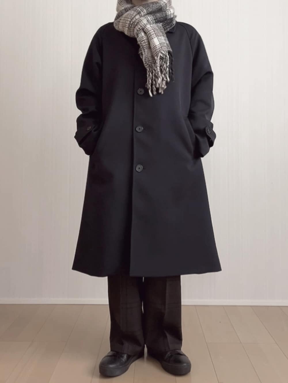 ブラック系のスニーカー、ブラウン系のスラックス、ブルー系のステンカラーコートを着用したメンズの冬コーディネートの5枚目の写真