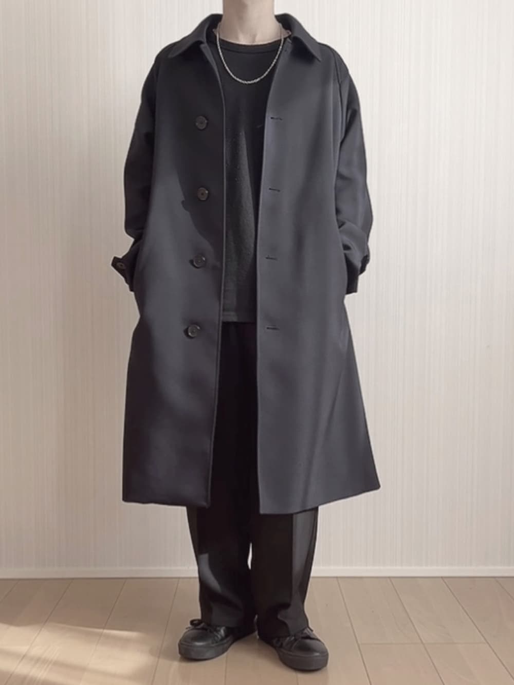 ブラック系のスラックス、ブラック系のスニーカー、ブルー系のステンカラーコートを着用したメンズの冬コーディネートの5枚目の写真