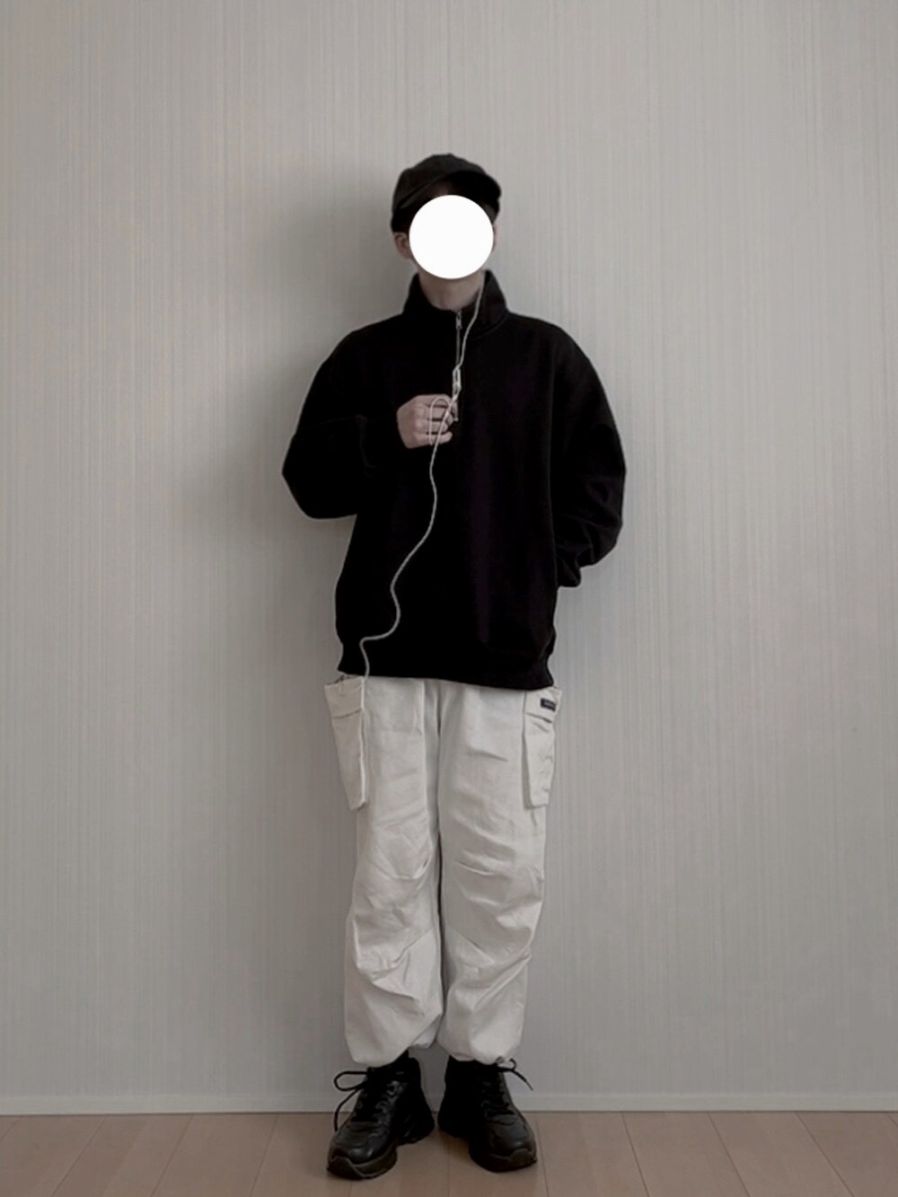 ホワイト系のカーゴパンツ、ブラック系のスニーカー、ブラック系のスウェットを着用したメンズの冬コーディネートの3枚目の写真