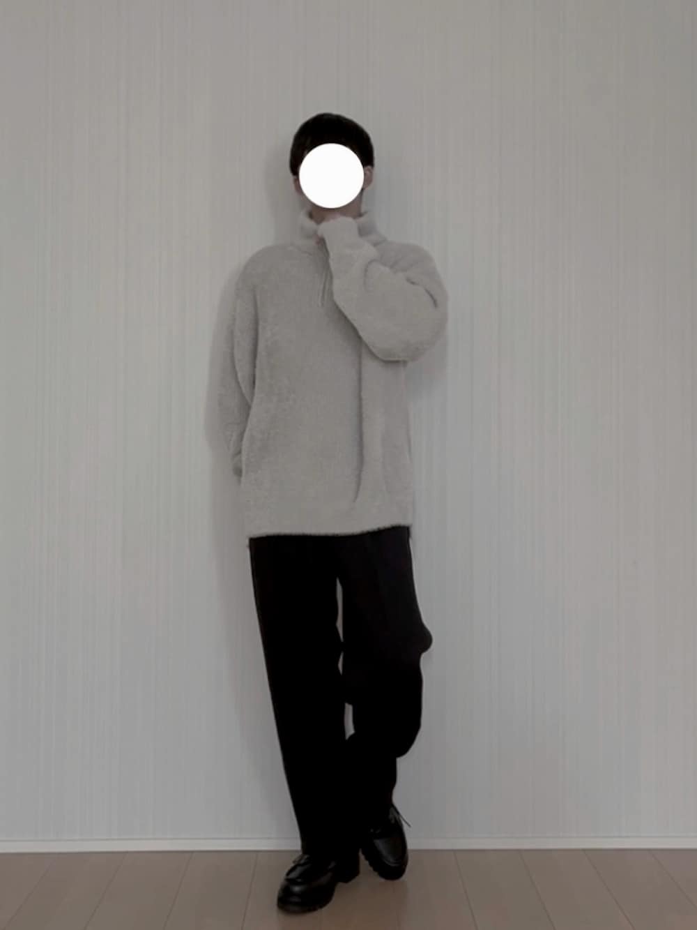 グレー系のニット/セーター、ブラック系のスラックス、ブラック系のモカシン/デッキシューズを着用したメンズの春コーディネートの3枚目の写真