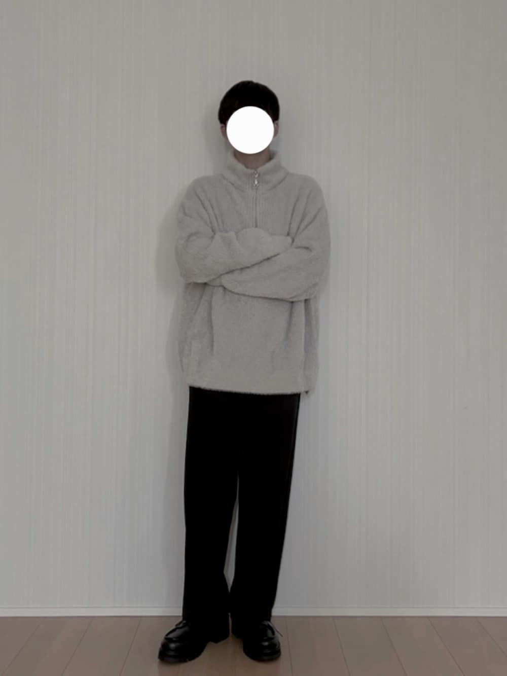 グレー系のニット/セーター、ブラック系のスラックス、ブラック系のモカシン/デッキシューズを着用したメンズの春コーディネートの2枚目の写真