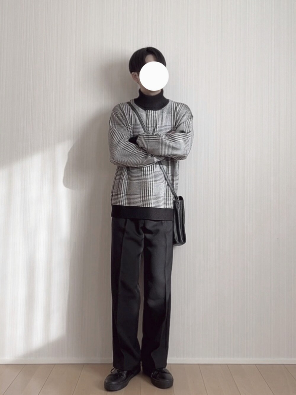 ブラック系のスラックス、ブラック系のスニーカー、ブラック系のニット/セーターを着用したメンズの冬コーディネートの3枚目の写真