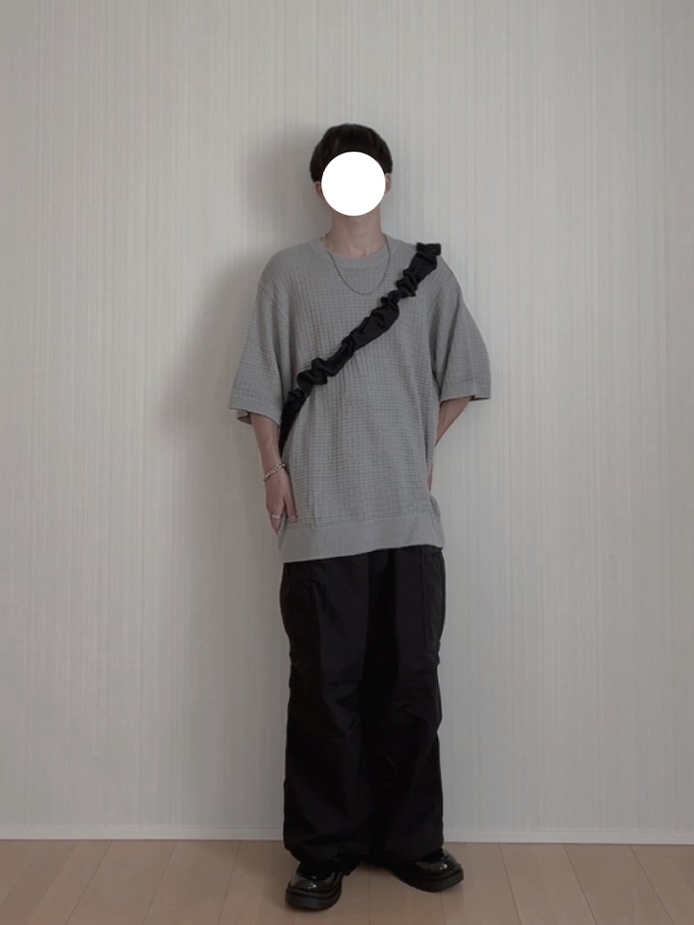 グレー系のニット/セーター、ブラック系のカーゴパンツ、ブラック系のローファーを着用したメンズの夏コーディネートの2枚目の写真