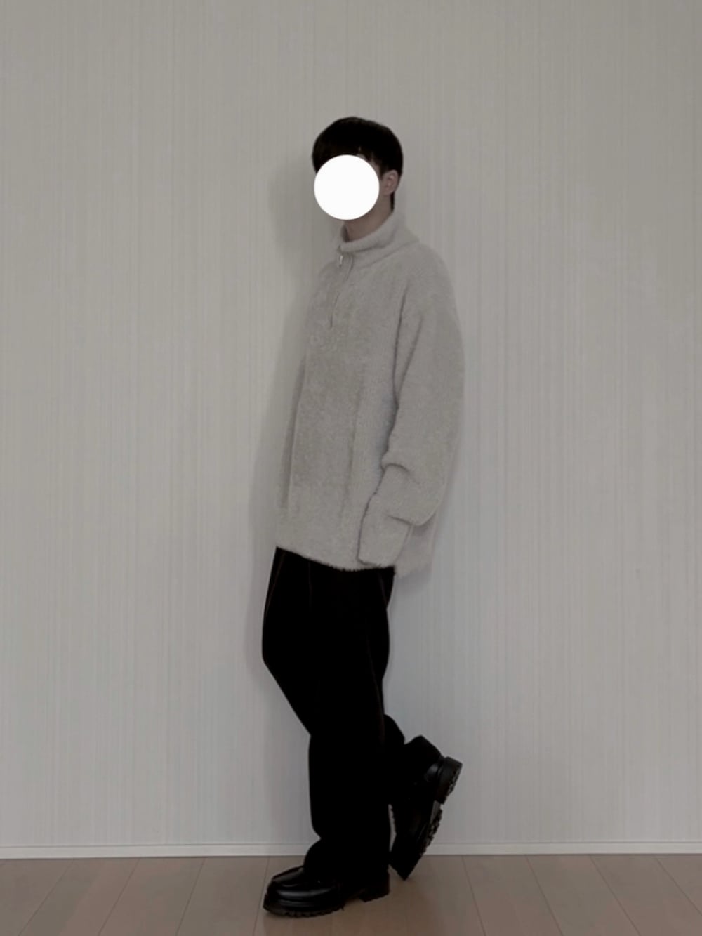 グレー系のニット/セーター、ブラック系のスラックス、ブラック系のモカシン/デッキシューズを着用したメンズの春コーディネートの4枚目の写真