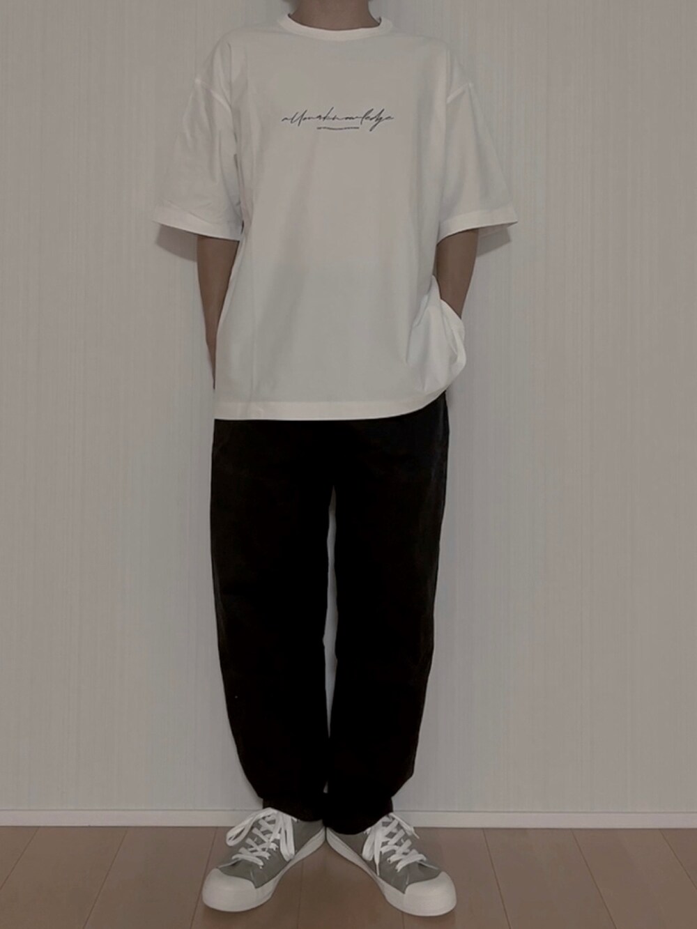 ホワイト系のTシャツ/カットソー、ブラック系のチノパンツ、グリーン系のスニーカーを着用したメンズの夏コーディネートの3枚目の写真