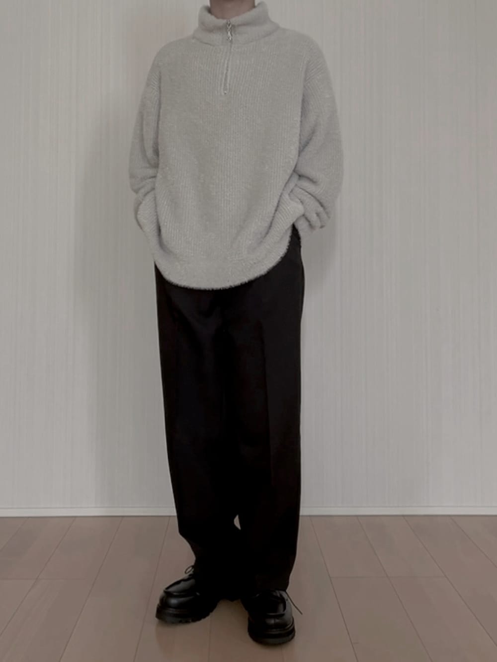 グレー系のニット/セーター、ブラック系のスラックス、ブラック系のモカシン/デッキシューズを着用したメンズの春コーディネートの5枚目の写真