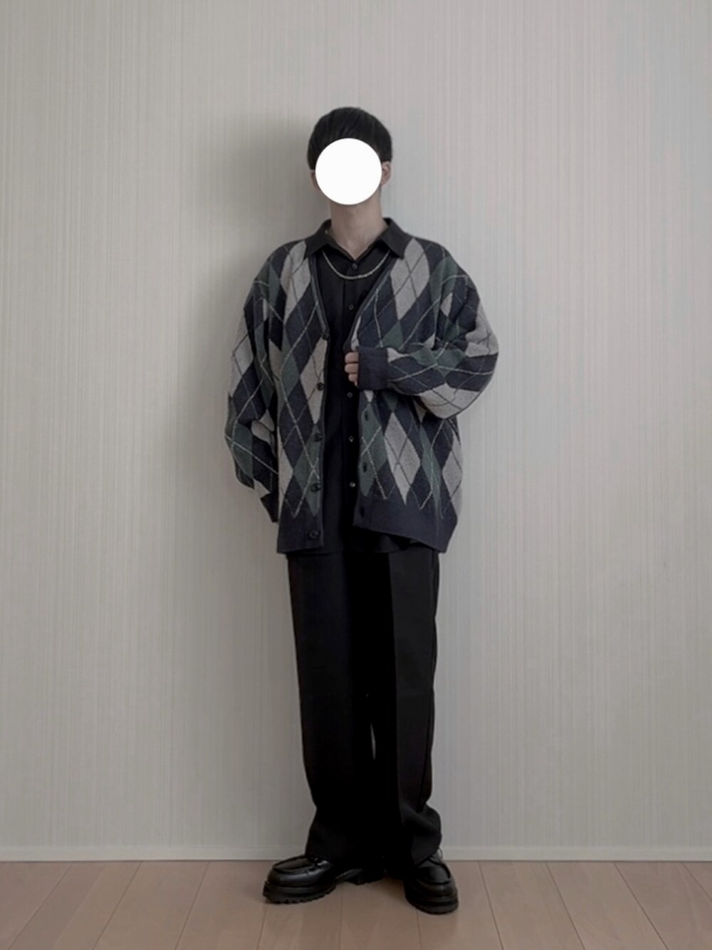 ブラック系のモカシン/デッキシューズ、ブラック系のスラックス、ブルー系のカーディガン/ボレロを着用したメンズの春コーディネートの4枚目の写真