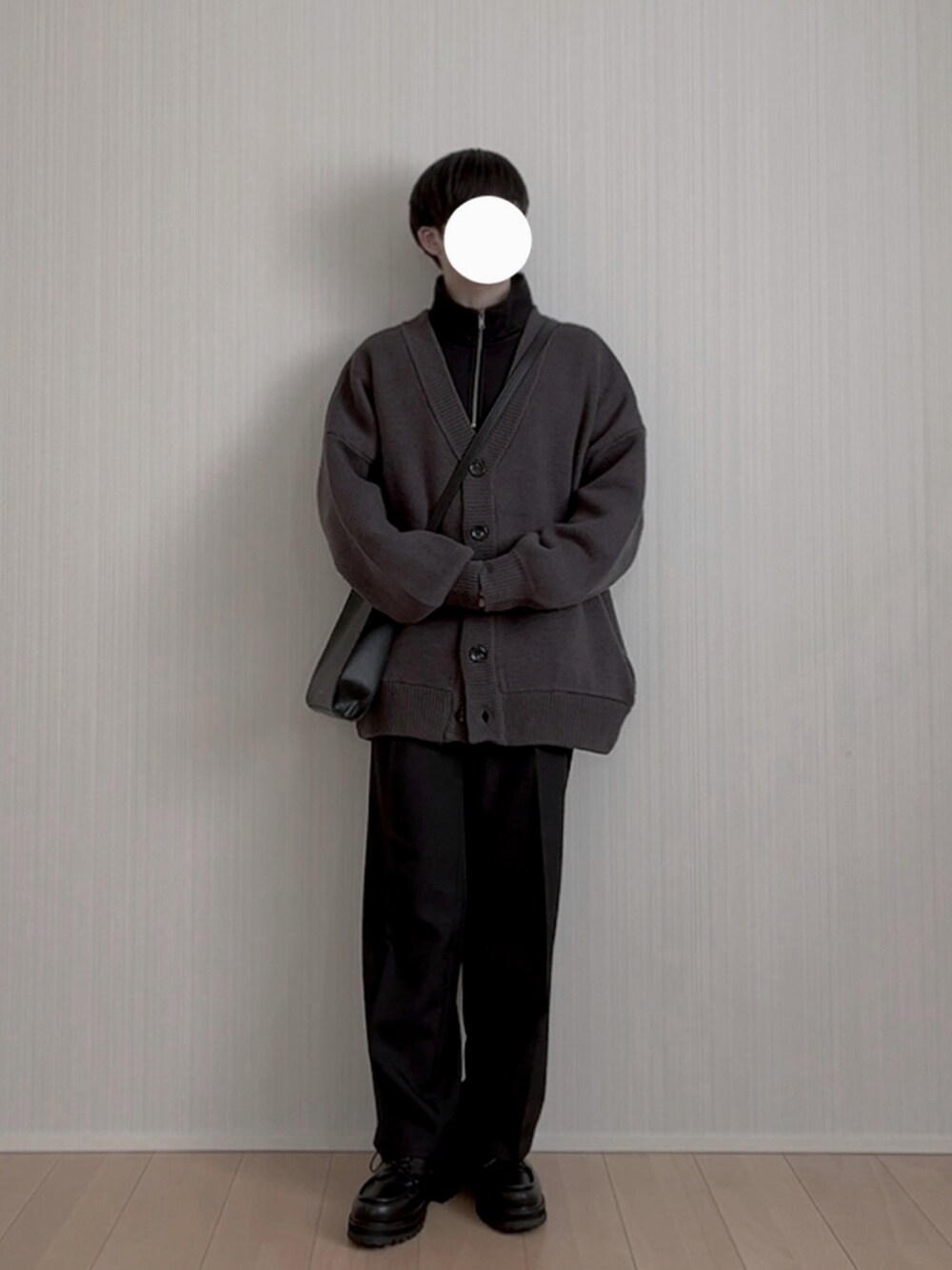 ブラック系のスラックス、ブラック系のモカシン/デッキシューズ、ブラック系のショルダーバッグを着用したメンズの冬コーディネートの2枚目の写真