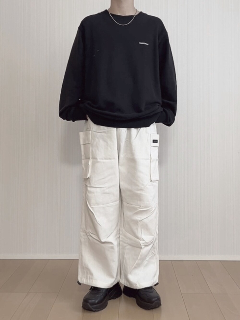 ブラック系のスニーカー、ホワイト系のカーゴパンツ、ブラック系のTシャツ/カットソーを着用したメンズの冬コーディネートの5枚目の写真