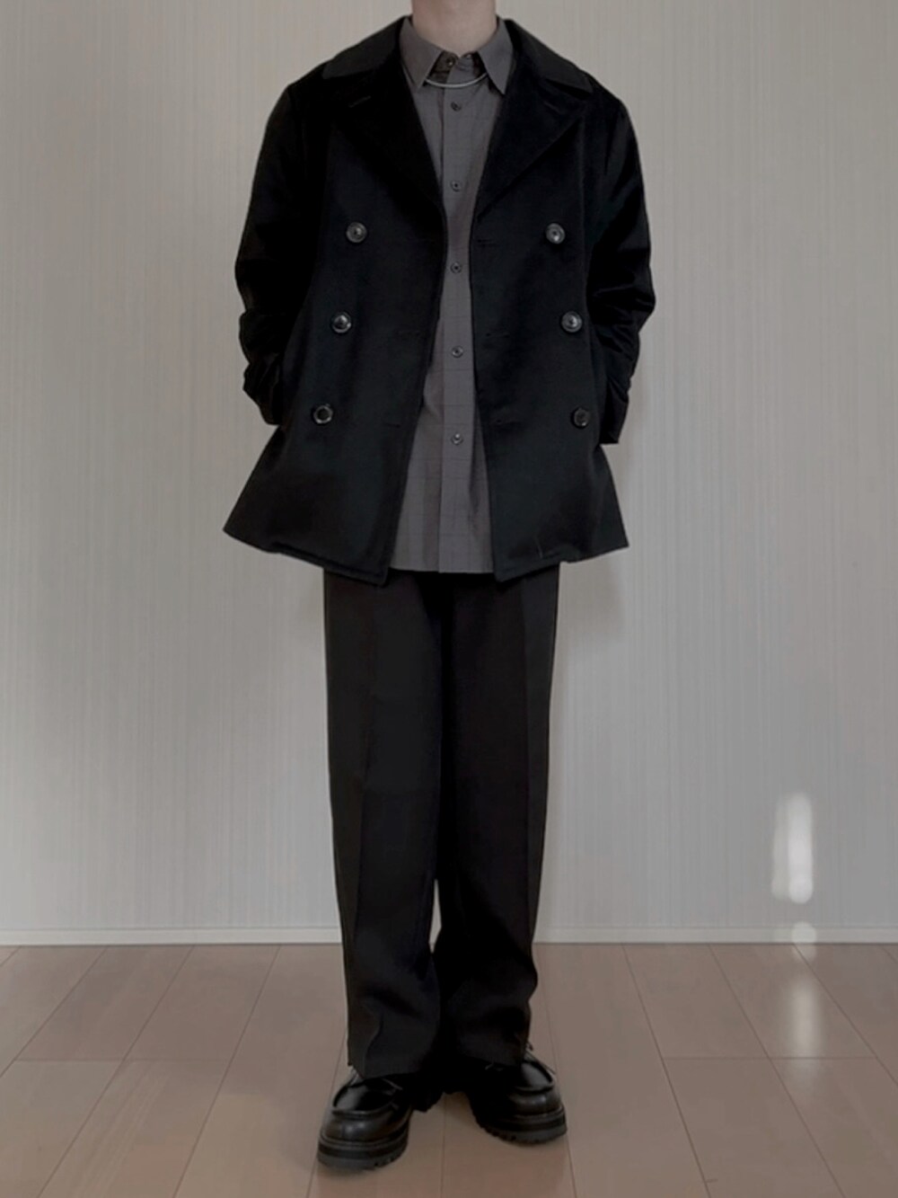 ブラック系のピーコート、グレー系のシャツ/ブラウス、ブラック系のスラックスを着用したメンズの春コーディネートの5枚目の写真