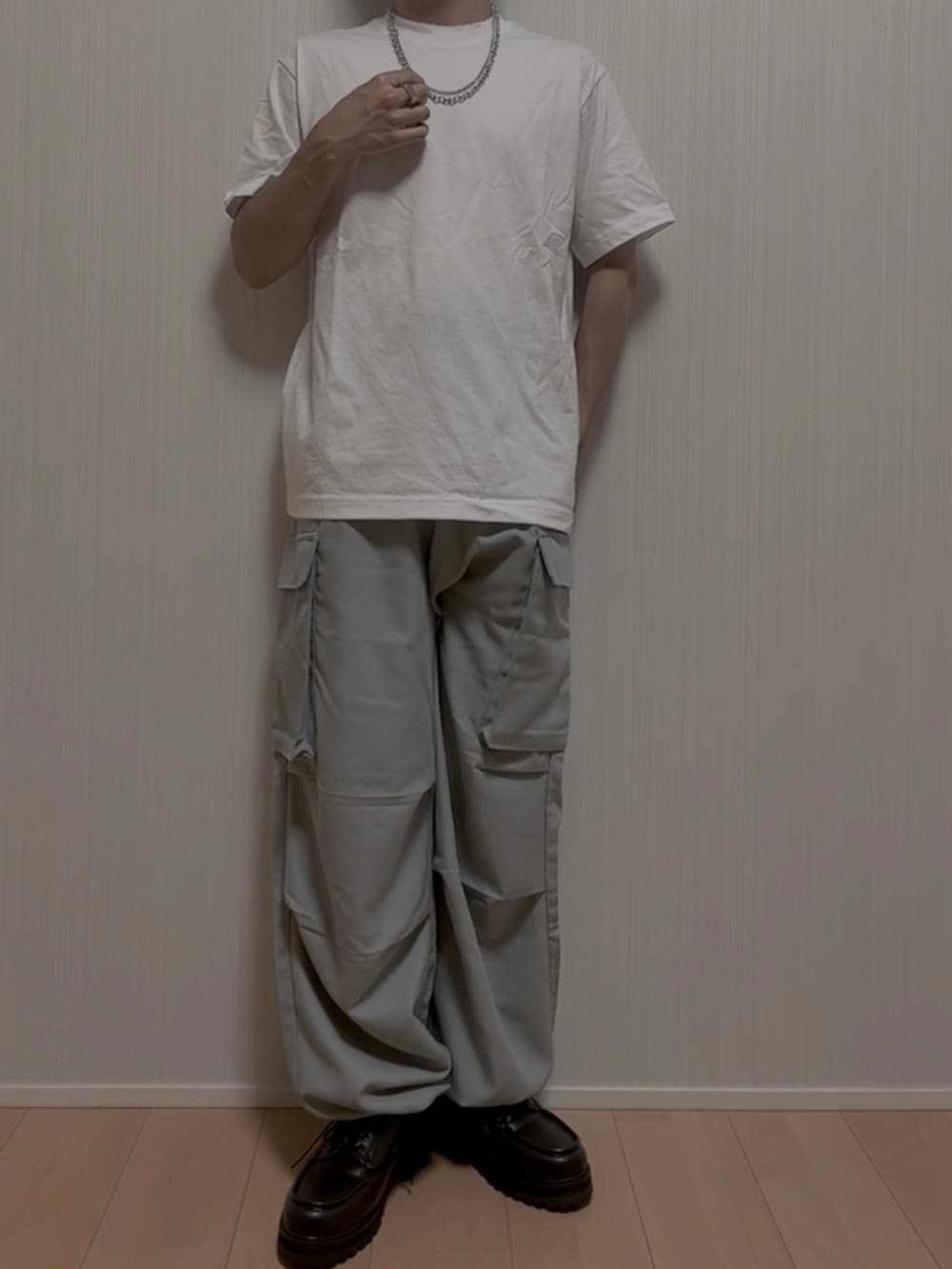 ホワイト系のTシャツ/カットソー、グレー系のカーゴパンツ、ブラック系のモカシン/デッキシューズを着用したメンズの夏コーディネートの3枚目の写真