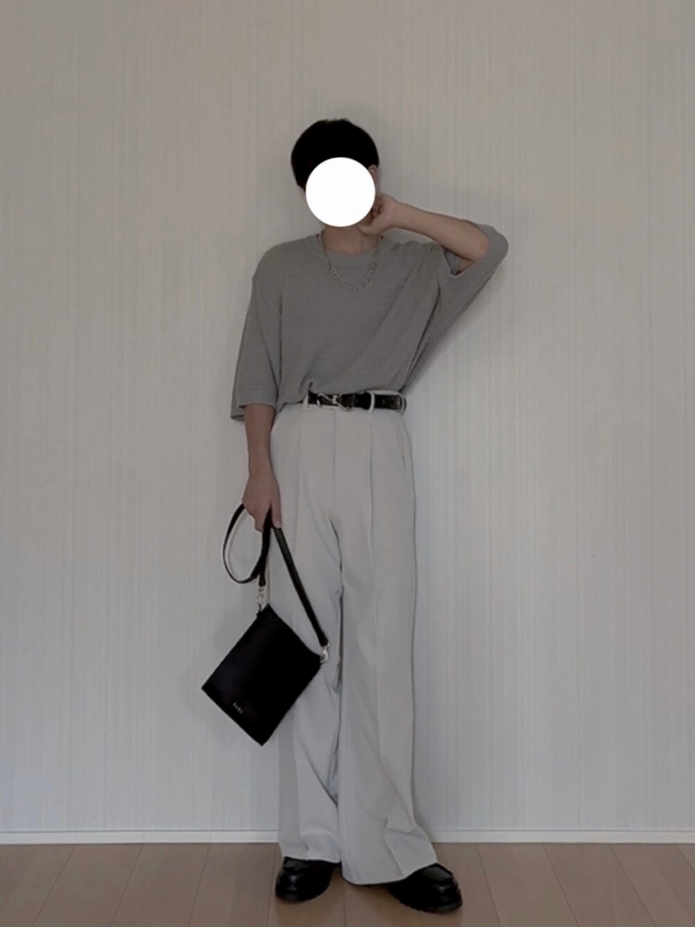 ブラック系のショルダーバッグ、グレー系のスラックス、ブラック系のモカシン/デッキシューズを着用したメンズの夏コーディネートの2枚目の写真