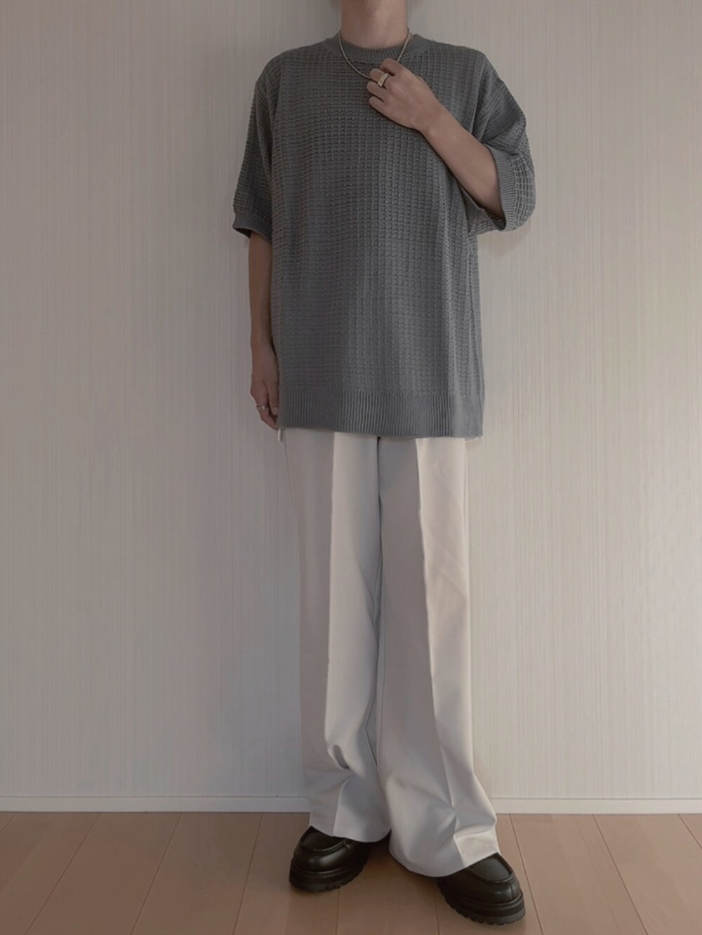 ブルー系のニット/セーター、グレー系のスラックス、ブラック系のモカシン/デッキシューズを着用したメンズの夏コーディネートの3枚目の写真