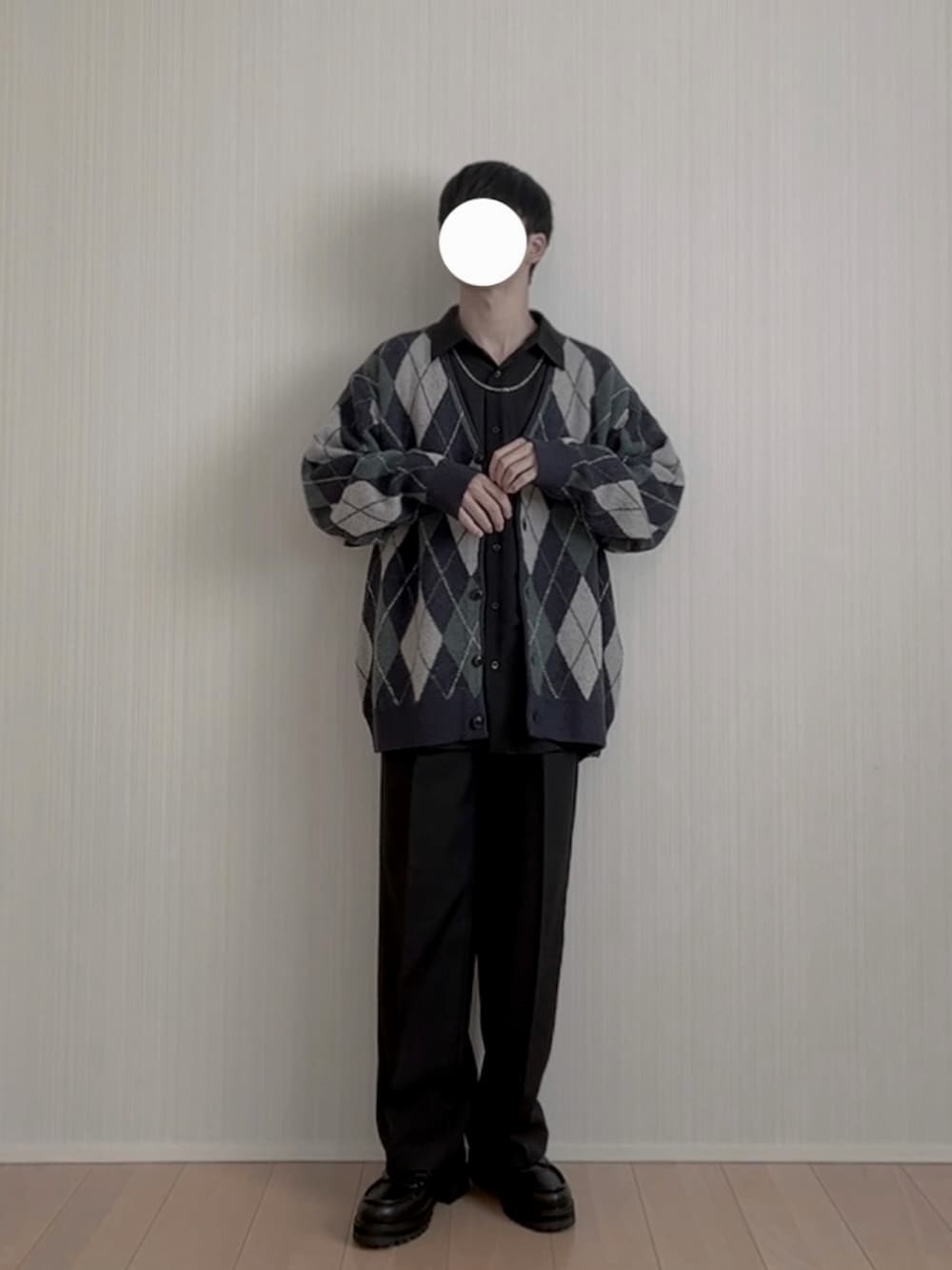 ブラック系のモカシン/デッキシューズ、ブラック系のスラックス、ブルー系のカーディガン/ボレロを着用したメンズの春コーディネートの3枚目の写真