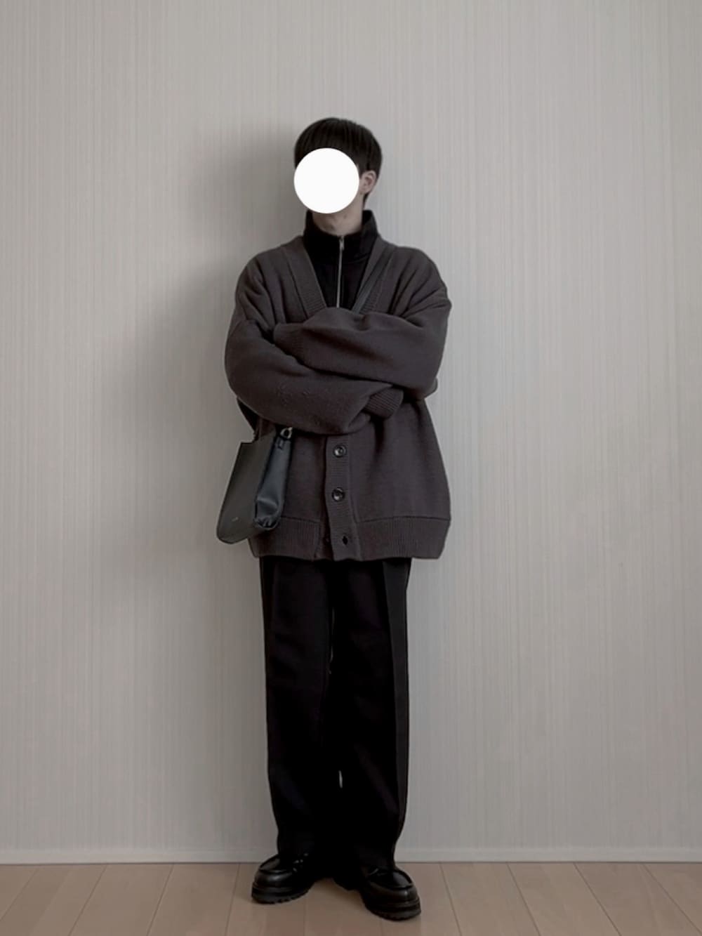 ブラック系のスラックス、ブラック系のモカシン/デッキシューズ、ブラック系のショルダーバッグを着用したメンズの冬コーディネートの4枚目の写真