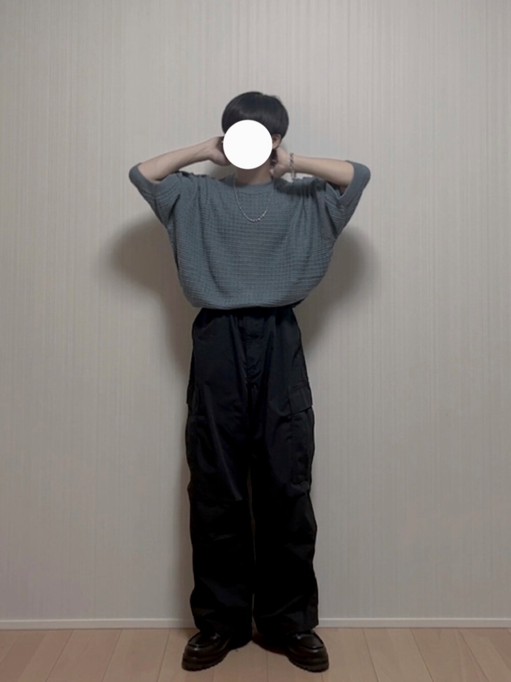 ブラック系のカーゴパンツ、ブラック系のモカシン/デッキシューズ、ブルー系のニット/セーターを着用したメンズの夏コーディネートの2枚目の写真