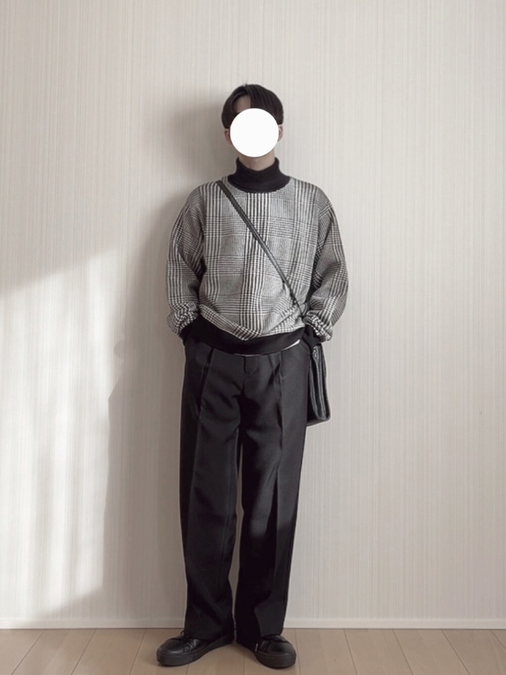 ブラック系のスラックス、ブラック系のスニーカー、ブラック系のニット/セーターを着用したメンズの冬コーディネートの4枚目の写真