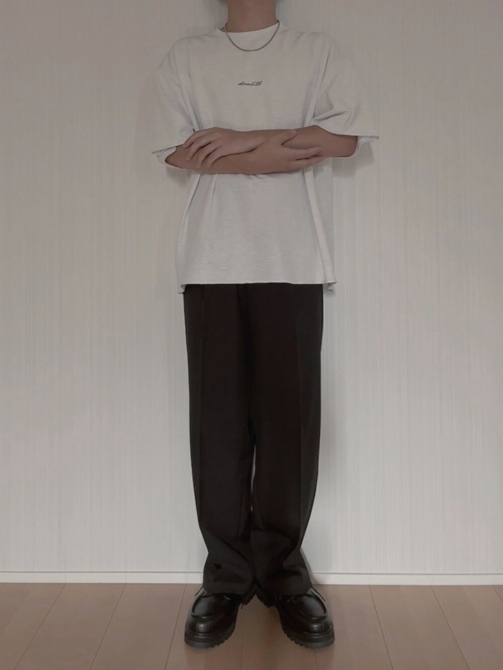 ホワイト系のTシャツ/カットソー、ブラック系のスラックス、ブラック系のモカシン/デッキシューズを着用したメンズの夏コーディネートの3枚目の写真