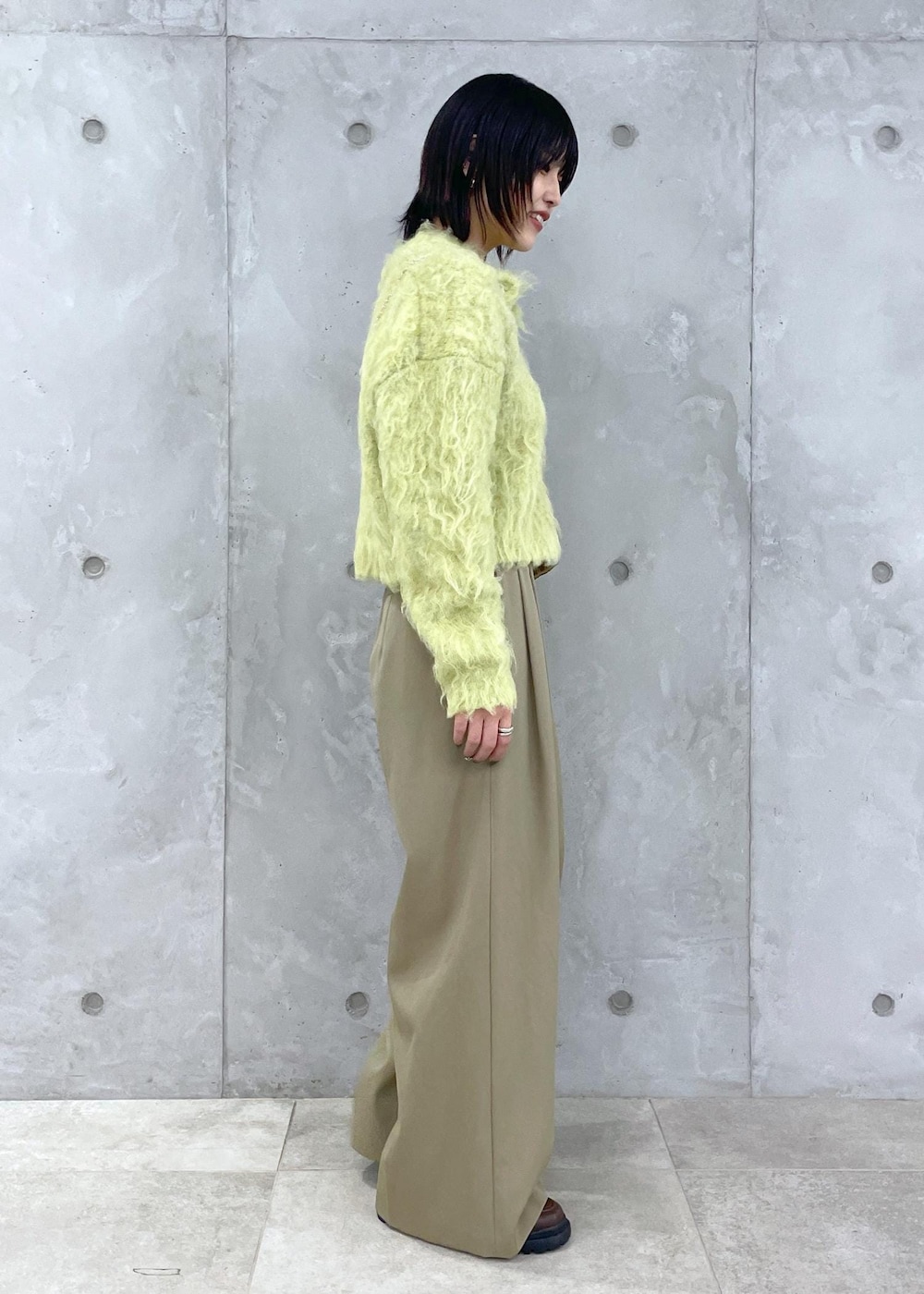 グリーン系のカーディガン/ボレロ、グリーン系のスラックス、ブラウン系のローファーを着用したレディースの秋コーディネートの5枚目の写真