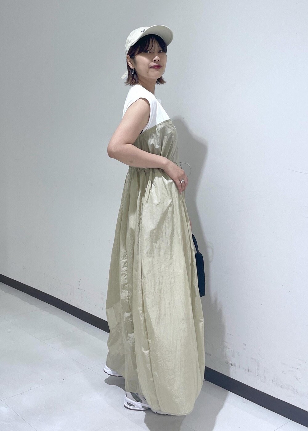 ブラウン系のハンドバッグ、ベージュ系のワンピース、ホワイト系のネックレスを着用したレディースの夏コーディネートの5枚目の写真