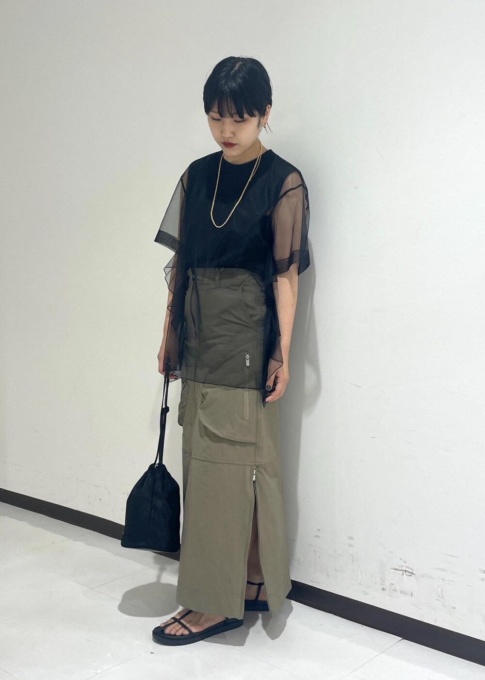 ブラック系のサンダル、ブラック系のショルダーバッグ、ベージュ系のスカートを着用したレディースの夏コーディネートの3枚目の写真