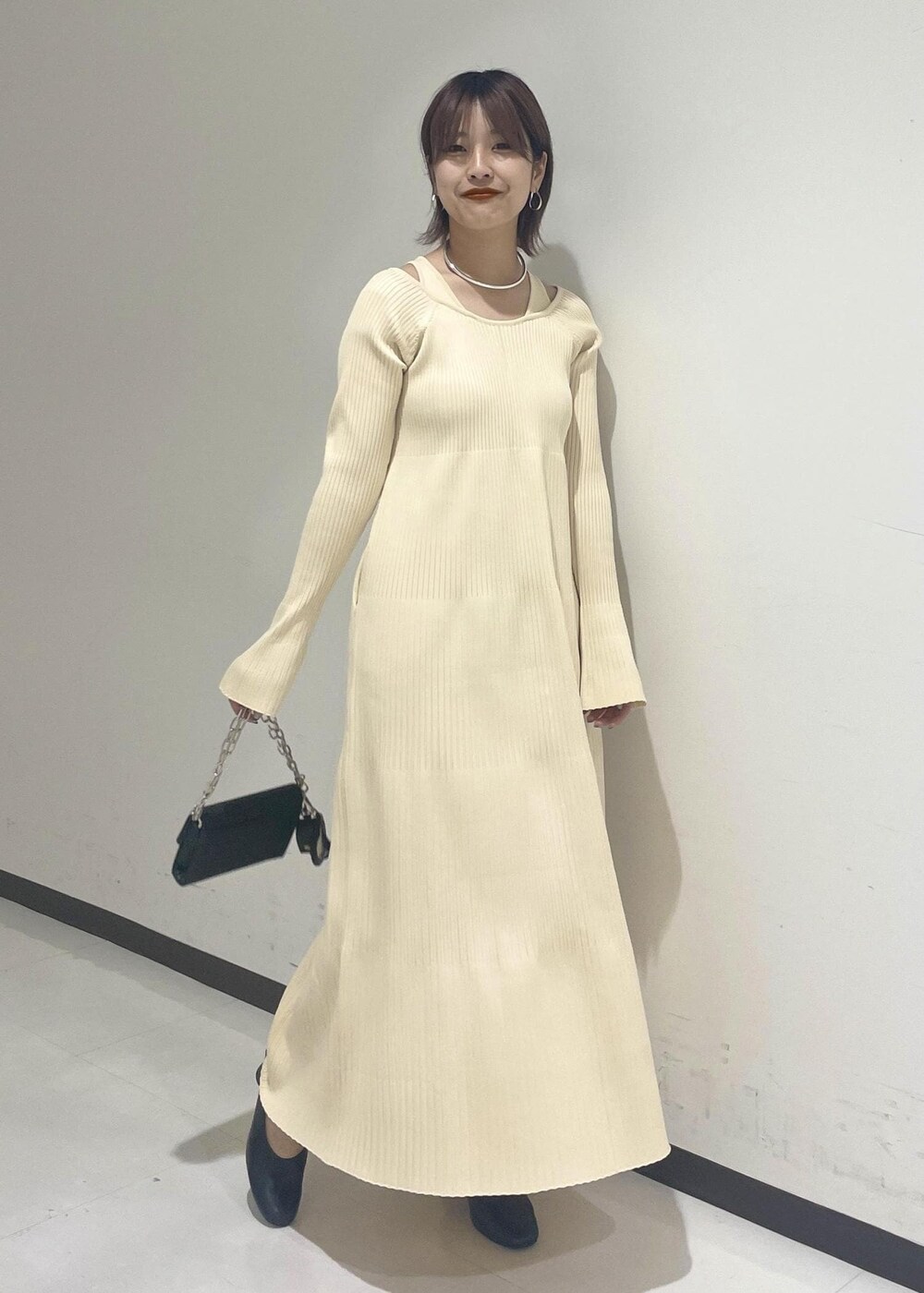 ブラック系のパンプス、シルバー系のチョーカーを着用したレディースの冬コーディネートの2枚目の写真