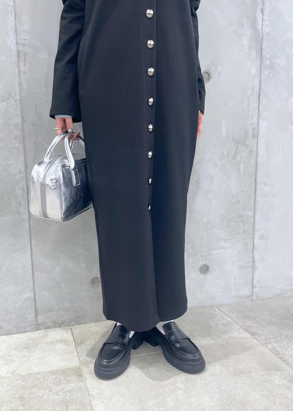 ブラック系のローファー、グリーン系のニット/セーター、シルバー系のショルダーバッグを着用したレディースの冬コーディネートの9枚目の写真